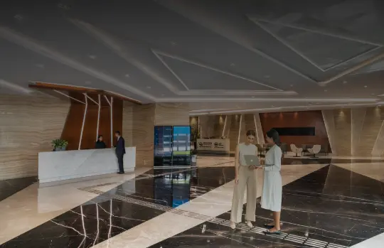 A person placing plastic bottles into a recycling bin in a lush green environment, as part of an effort to reduce waste and promote sustainability.