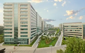 Aerial view of a modern office complex with multiple glass buildings and landscaped green spaces.