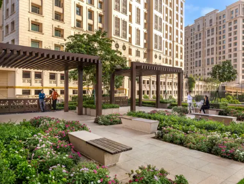 A serene garden with benches and pergolas at Downtown Powai, Mumbai. Lush greenery and flowers create a peaceful outdoor environment for relaxation.
