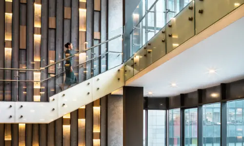 Modern office interior at Candor TechSpace, Sector 48, Gurugram, featuring a sleek glass staircase and contemporary design elements