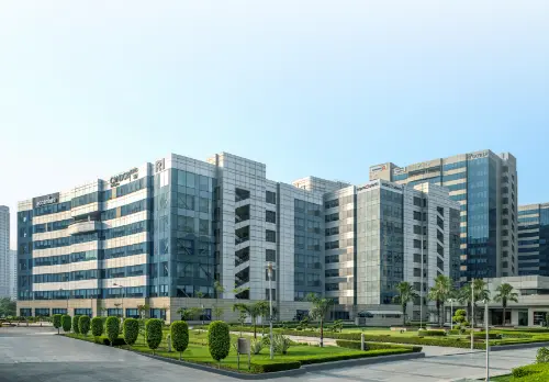 A playful public art installation at Candor TechSpace featuring colorful wheels and sculptures of ducks, with a person walking past in the background.