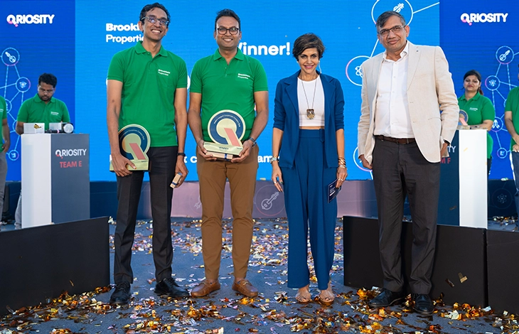 A person asking a question with a microphone at a seminar or conference, with an audience listening attentively.