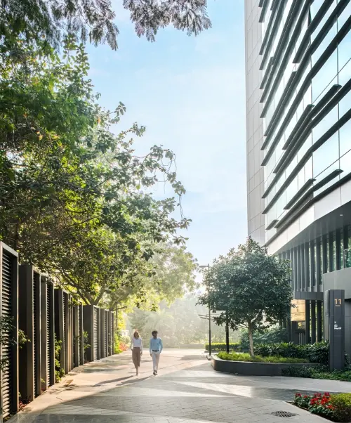 Candor TechSpace, Sector 48, Gurugram, featuring a modern office building with lush greenery and a pedestrian walkway.