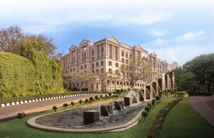 Fairmont, Downtown Powai, Mumbai, featuring a grand neoclassical-style building with an elegant water fountain and lush greenery.