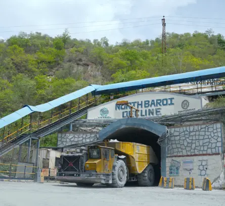 Entrance of the North Baroi Decline mining tunnel with a large yellow mining truck exiting