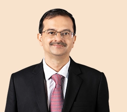 Portrait of Rakesh Jha, Executive Director of ICICI Bank, dressed in a black suit and pink tie, representing his leadership role within the bank.