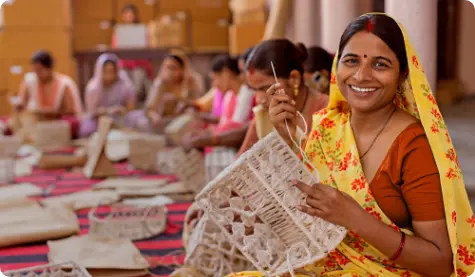 A vibrant image depicting an Indian woman in a yellow saree, joyfully crafting traditional handicrafts alongside other women in the background. The scene highlights the empowerment of women through skill development and community-driven economic activities.