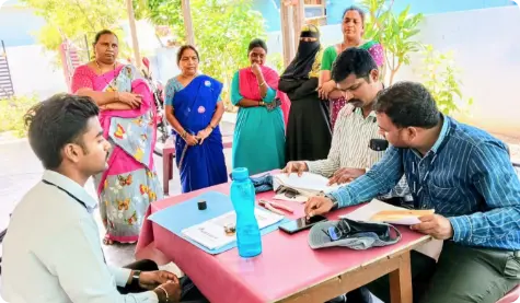 ICICI Bank representatives providing information about SHG loans to members of a Self-Help Group (SHG) in Palakurthy, Jangaon District, Telangana. The image shows a discussion taking place at an outdoor table, with SHG members attentively listening, highlighting ICICI Bank's efforts to empower rural communities through financial inclusion and support.