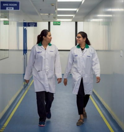 Two Women in Lab coats walking in a hallway